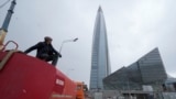 FILE - A worker sits on his water tank truck next to the business tower Lakhta Centre, headquarters of Russian gas monopoly Gazprom in St. Petersburg, Russia, April 27, 2022.