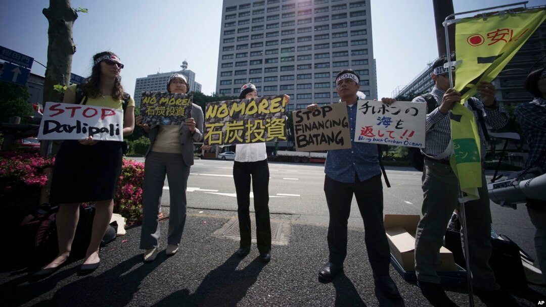 A group of people state a protest against climate change and coal investments, ahead of the G7 Finance Ministers and Central Bank Governors' Meeting, in front of the Ministry of Finance in Tokyo on May 19, 2016.