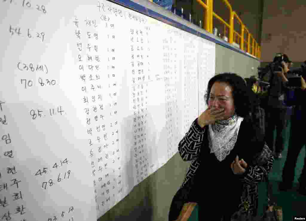 A mãe de um passageiro que estava no ferry afundado emocianada ao ver que o nome do seu filho consta da lista dos sobreviventes resgatados e abrigados no ginásio de Jindo, Coreia do Sul, Abril 16, 2014.