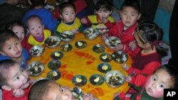 In this photo released by the World Food Program, North Korean children eat a lunch, including rice provided by the U.N. World Food Program.