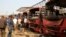FILE - Bomb experts search for evidence in front of buses at a bomb blast scene at Nyanyan in Abuja, April 14, 2014. 