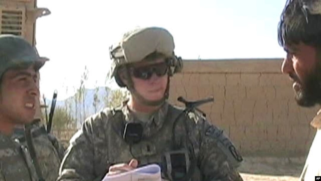 Army 1st Lieutenant Sean Mahard (C) talks with Afghans in Logar province