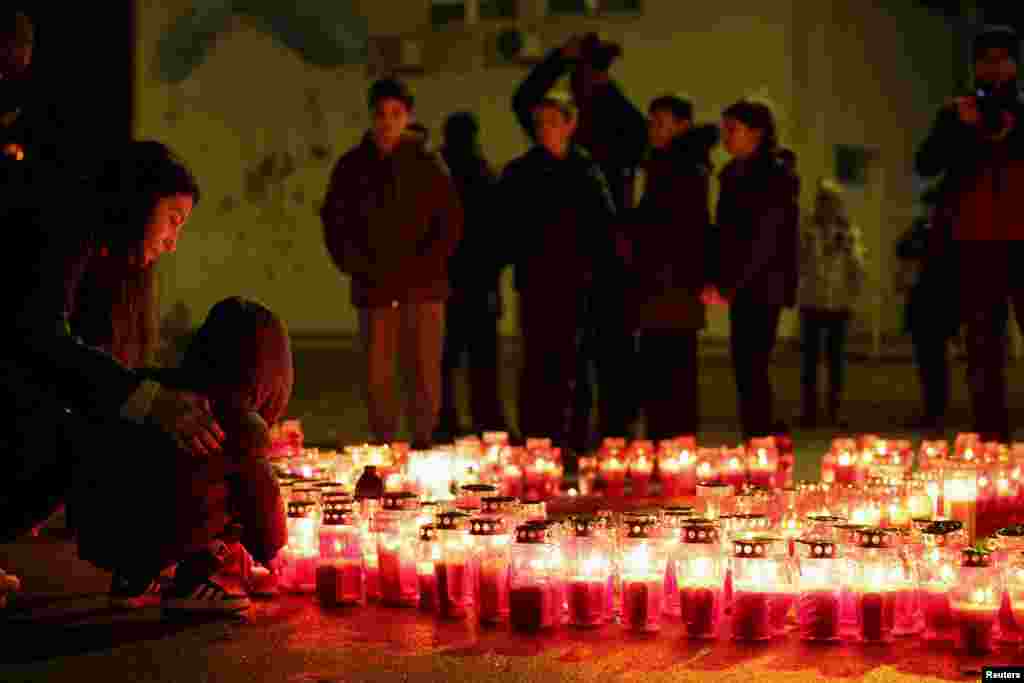 A child lays a candle following a knife attack in a primary school, in Zagreb, Croatia.