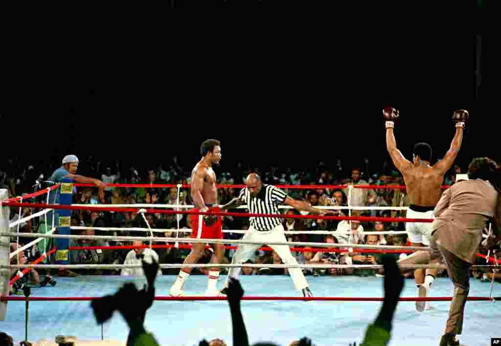 Challenger, Muhammad Ali lève les bras en signe de victoire alors que le champion George Foreman est compté par l&#39;arbitre Zack Clayton, à la fin du combat du championnat WBA / WBC à Kinshasa, au Zaïre, le 30 Octobre, 1974. Ali reprend la couronne comme le champion du monde poids lourd incontesté par KO au huitième round de leur combat surnommé &laquo;Rumble in the Jungle&raquo;. (AP Photo) 