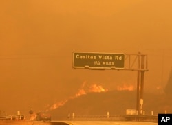 Flames and smoke shroud State Route 33 as a wildfire burns in Ventura, California, Dec. 5, 2017.