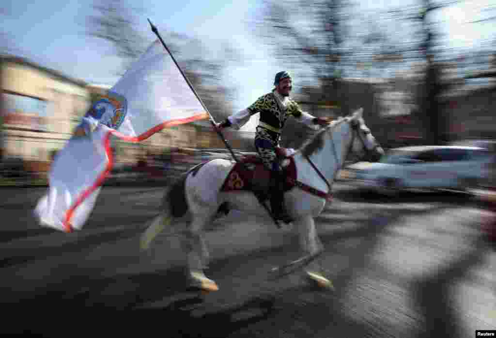 A reveler rides a horse as he holds a city flag during a parade as part of Newroz celebrations, an ancient holiday marking the spring equinox, in Almaty, Kazakhstan.