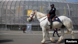 FILE - A French policeman patrols on a horse during a mock chemical attack drill at the Pierre Mauroy stadium in Villeneuve d'Ascq, France, April 21, 2016, in preparation of security measures for the 2016 European football championship.