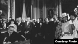 Photograph of President Lyndon Johnson signing the Voting Rights Act as Martin Luther King, Jr., with other civil rights leaders in the Capitol Rotunda, Washington, DC, August 6, 1965. Creative Commons