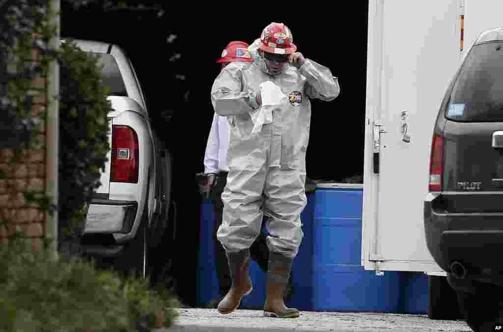 A worker wears a hazard suite in a staging area at a health care worker&#39;s apartment, who tested positive for Ebola in Dallas, Oct. 13, 2014. 