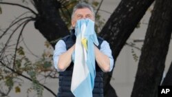 El presidente argentino Mauricio Macri sostiene una bandera nacional durante un evento en Buenos Aires, Argentina, el sábado 28 de septiembre de 2019. (AP Foto/Natacha Pisarenko).