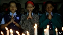 India schoolgirls offer prayers for victims killed in a Taliban attack on a Pakistan military-run school, in Mumbai, India, Dec. 17, 2014. 