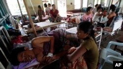 Family members sit with injured Rakhine men as they receive medical treatment at Thandwe hospital , Burma, Oct. 2, 2013.