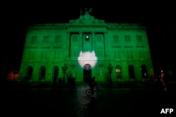 FILE - The City Hall of Barcelona is illuminated in green in support of the Paris climate accord aiming to meet greenhouse gas emission targets, in Barcelona, Spain, June 2, 2017.