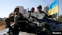 Tentara Ukraina dalam kendaraan lapis baja di Mariupol (5/9). (Reuters/Vasily Fedosenko)