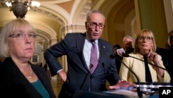 FILE - Senate Minority Leader Sen. Chuck Schumer of N.Y., accompanied by Sen. Patty Murray, D-Wash., left, and Sen. Maggie Hassan, D-N.H., right, speaks to reporters as Senate Republicans faced defeat on the Graham-Cassidy bill.