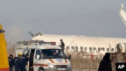 La policía hace guardia mientras los socorristas ayudan en el lugar del accidente aéreo cerca del aeropuerto internacional de Almaty, en Kazajistán, el viernes 27 de diciembre de 2019. 