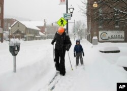 Nicjolas Nicolet y su hijo Rocco practican esquí de montaña en Montpelier, Vermont, aprovechando la nieve de la más reciente tormenta invernal en el área. Domingo 20 de enero de 2019.