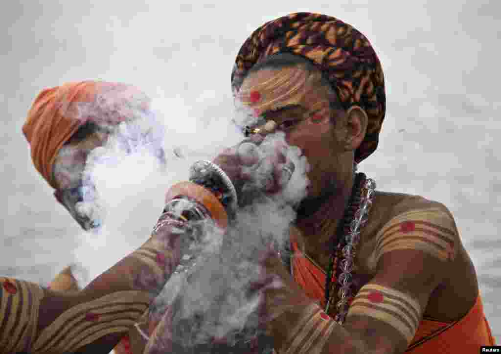 인도 라자스탄주 푸시카르에서 힌두교 은둔자들이 관례에 따라 &#39;칠룸&#39; 이라는 대통으로 흡연하고 있다.