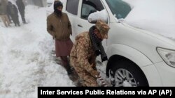 巴基斯坦軍人在救助因旅遊勝地穆里大雪被困車內的遊客.