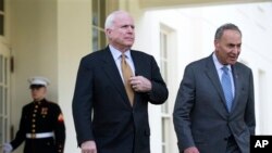 Sen. John McCain, left, and Sen. Charles Schumer, walk out of the White House in Washington, April 16, 2013