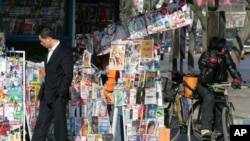 Chinese man stops at a news stand on a street in Beijing (file photo)