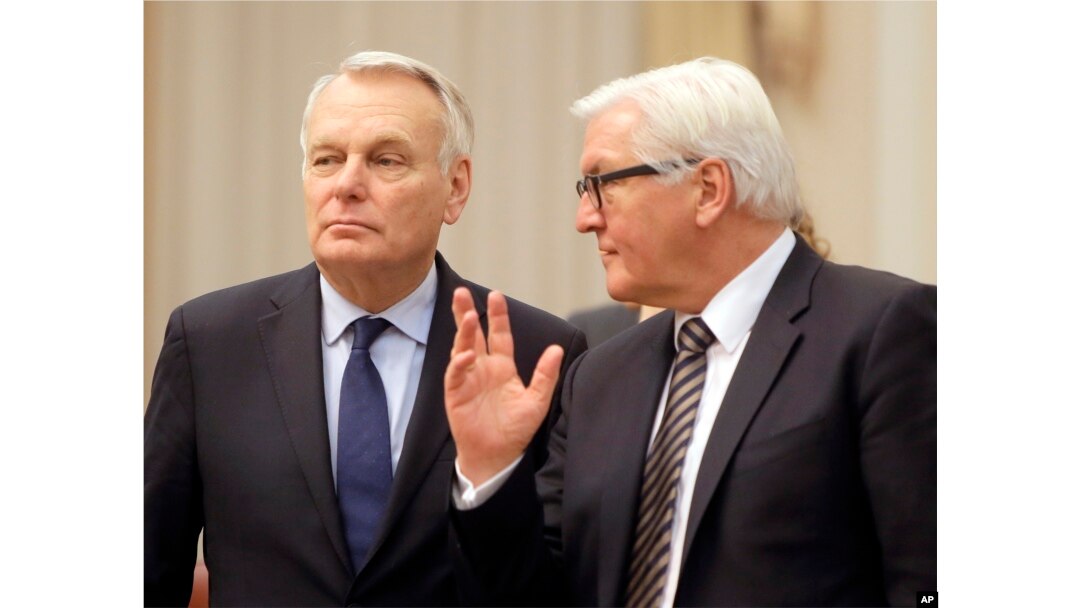 German Foreign Minister Frank-Walter Steinmeier, right, and French Foreign Minister Jean-Marc Ayrault talk ahead of their meeting with Ukrainian officials in Kiev, Feb. 22, 2016. Germany and France are pushing for Ukraine to move ahead with reforms needed in order to implement the year-old Minsk peace agreement.