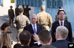 FILE - U.S. Defense Secretary Jim Mattis, center, speaks to the media as South Korean Defense Minister Song Young-moo, right, looks on during a visit to the truce village of Panmunjom in the Demilitarized Zone, Oct. 27, 2017.