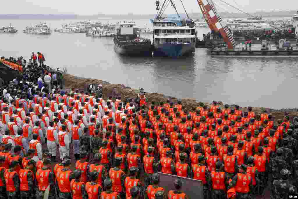 Rescue workers hold a moment of silence at a ceremony to mark the seventh day since the Eastern Star went down in the Jianli section of Yangtze River, Hubei province, China.