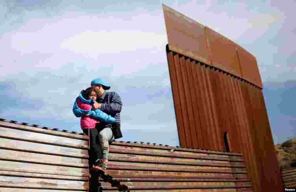 온두라스 출신 이민자 남성이 딸과 함께 미-멕시코 국경을 불법으로 넘고 있다.