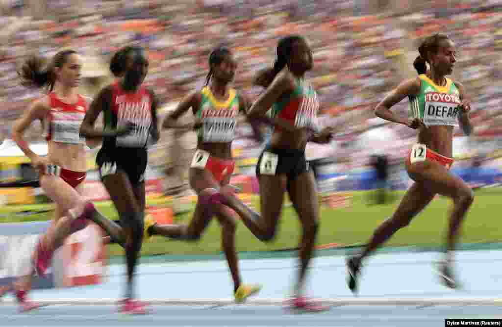 Meseret Defar (R) of Ethiopia competes in the women's 5000 metres final during the IAAF World Athletics Championships at the Luzhniki stadium in Moscow August 17, 2013. REUTERS/Dylan Martinez (RUSSIA - Tags: SPORT ATHLETICS) - RTX12OTC