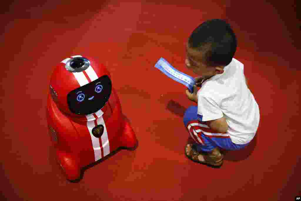 Seorang anak mengamati &quot;robot pintar&quot; pada konferensi robot dunia di Beijing, China.