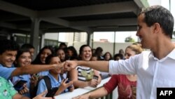El líder opositor venezolano y autoproclamado presidente Juan Guaidó saluda a los estudiantes, durante una visita a la escuela privada Los Corales, a la que asistió de niño, en el estado Vargas, en Venezuela.