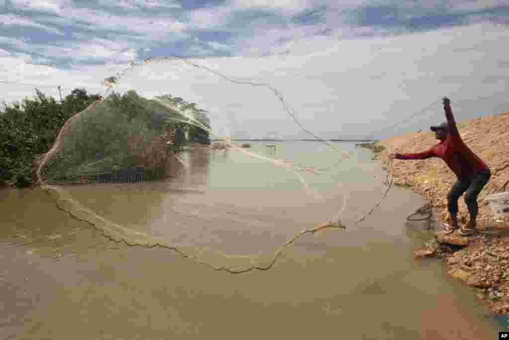 A local fisherman casts his net into the Boeung Ta Moak lake on the outskirts of Phnom Penh, Cambodia.