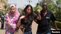 Injured woman is helped out of Westgate Shopping Centre where gunmen went on shooting and grenade-throwing spree, Nairobi Sept. 21, 2013.