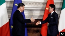 Chinese President Xi Jinping, left, and Italian Prime Minister Giuseppe Conte shake their hands following the signing of a memorandum in support of Beijing's "Belt and Road" initiative, at Rome's Villa Madama, March 23, 2019.