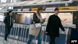 在纽约肯尼迪国际机场，人们经过汉莎航空公司的柜台。（2020年3月12日）
