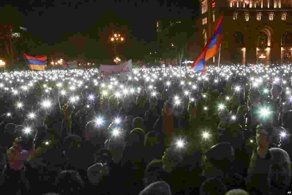 Supporters of Armenian Prime Minister Nikol Pashinyan hold up their phones during a rally in the center of Yerevan.
