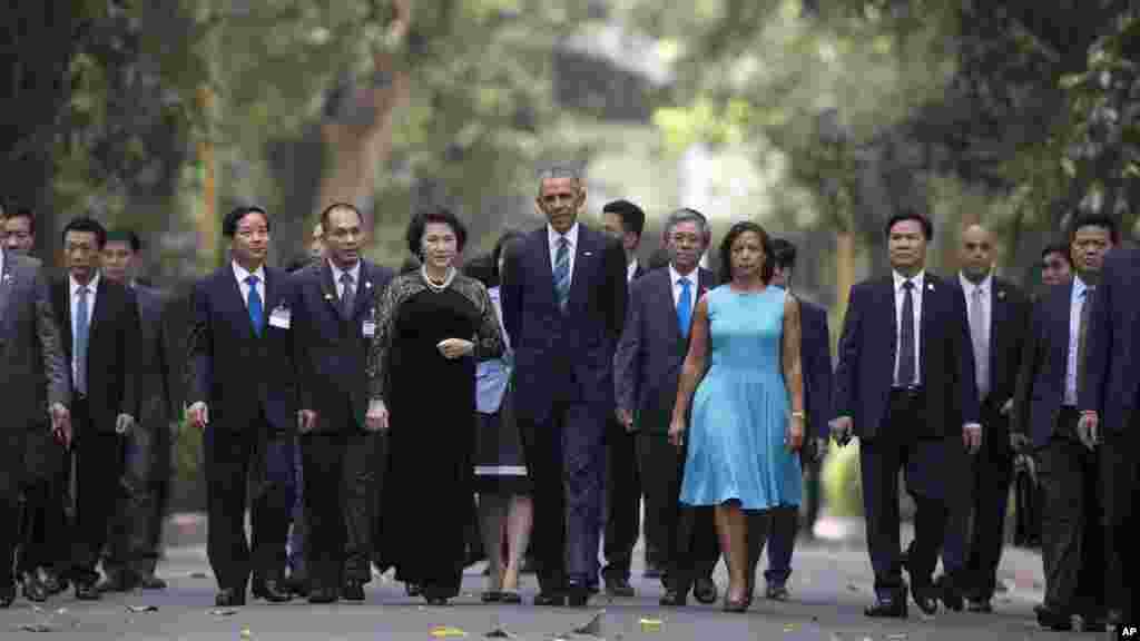 Le président américain Barack Obama, au centre, se promène avec la présidente de l&#39;Assemblée nationale Nguyen Thi Kim Ngan, centre gauche, sur le composé Palais présidentiel à Hanoi, au Vietnam, le lundi 23 mai 2016