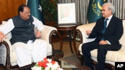 In this photo released by the Pakistan Press Information Department, President of Pakistan Mamnoon Hussain, left, talks with new Care Taker Prime Minister Nasir-ul-Mulk in Islamabad, June 1, 2018. 