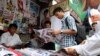 Customers buy local weekly journals at a road side shop in Rangoon, Burma, August 20, 2012 file photo.