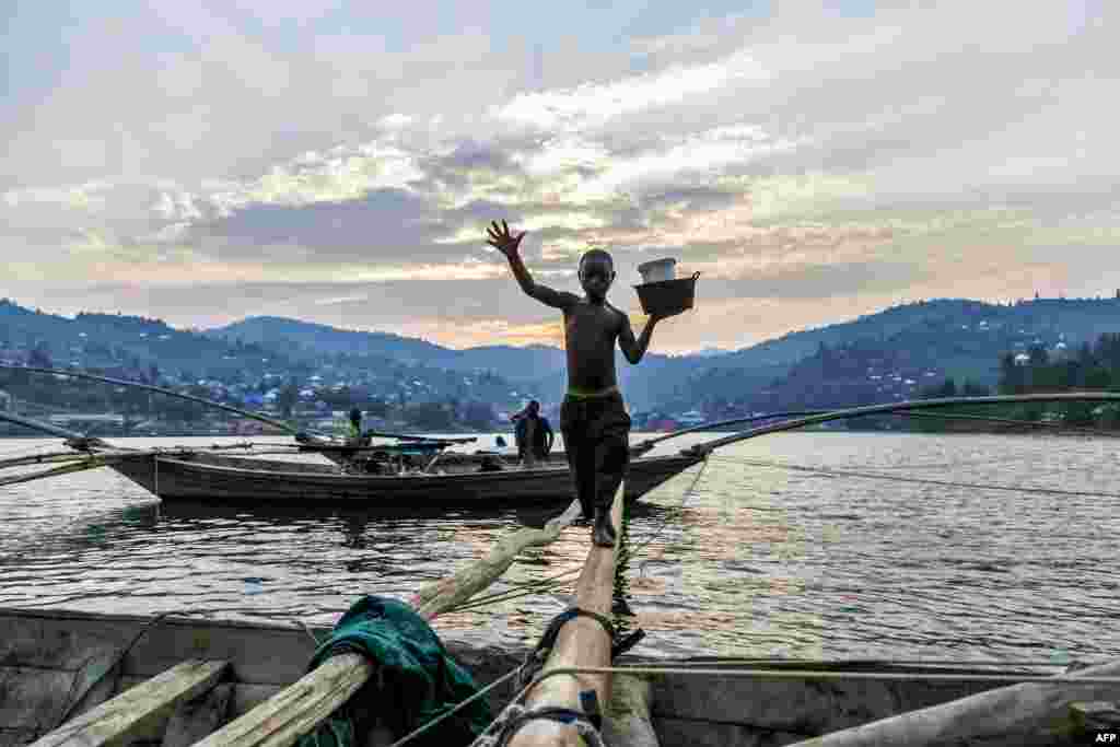 Izabayo, 13 years old, leaves the boat where he spent the night with 10 other fishermen after another fishing night at Lake Kivu.