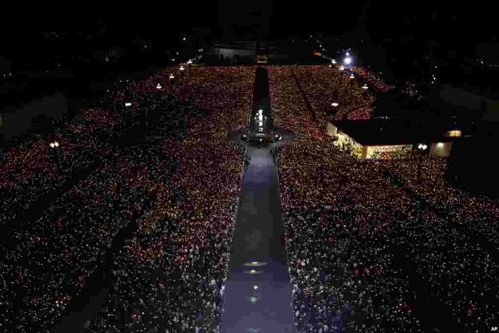 Ribuan ummat Katholik menyalakan lilin di Fatima, Portugal, tempat di mana tiga anak gembala pernah melihat penampakan Bunda Maria pada tahun 1917.