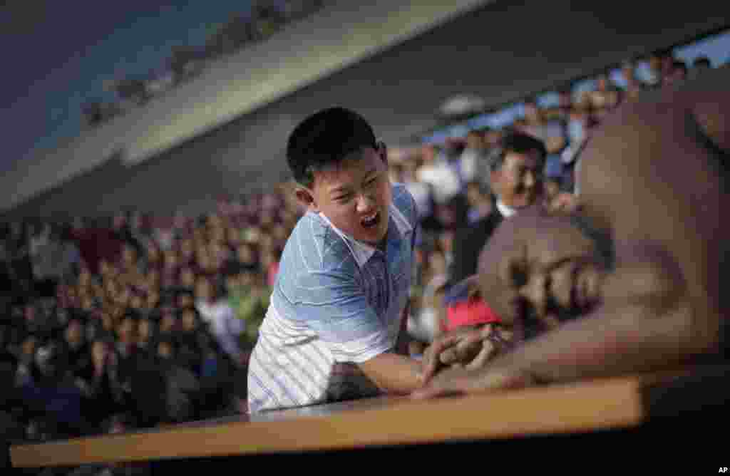 지난달 29일 프로레슬링대회에 참가하기 위해 평양을 방문한 미국의 밥 샙(오른쪽) 선수가 북한 어린이와 팔씨름을 하고 있다.