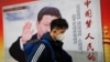 资料照：一名男子走过北京街头中国领导人习近平的宣传画。