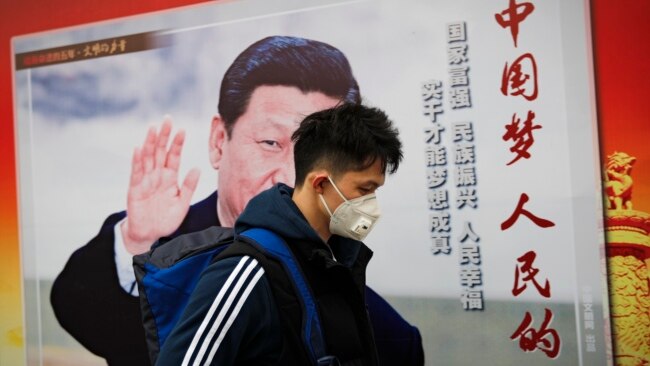 资料照：一名男子走过北京街头中国领导人习近平的宣传画。