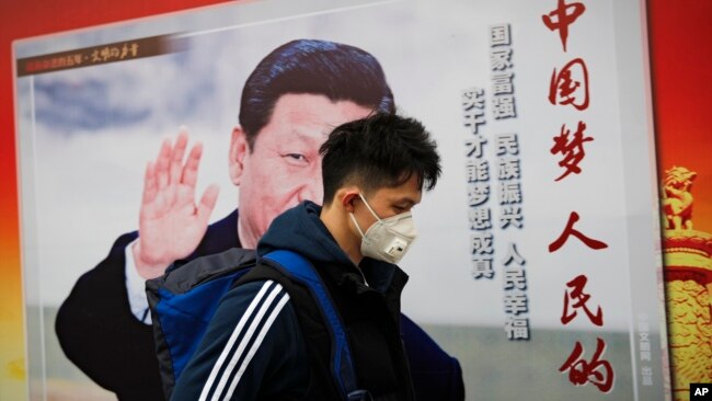 资料照:一名男子走过北京街头中国领导人习近平的宣传画。