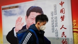 资料照 - 一名戴口罩防护空气污染的男子走过中共领导人习近平宣传画。