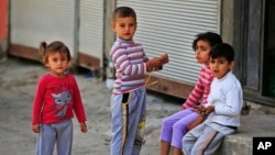 FILE - Syrian refugee children pass time in a neighborhood of the city of Gaziantep, southeastern Turkey.