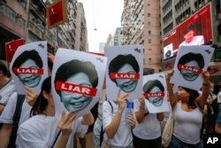 Protesters hold pictures of Hong Kong Chief Executive Carrie Lam as protesters march along a downtown street against the proposed amendments to an extradition law in Hong Kong Sunday, June 9, 2019.19.