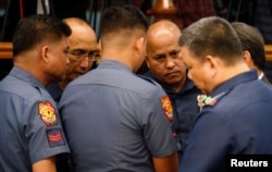 Philippine National Police chief Director-General Ronald dela Rosa (2nd-R) talks to fellow police officers during a Senate hearing regarding people killed during a crackdown on illegal drugs in Pasay, Metro Manila, Philippines, Aug. 23, 2016.